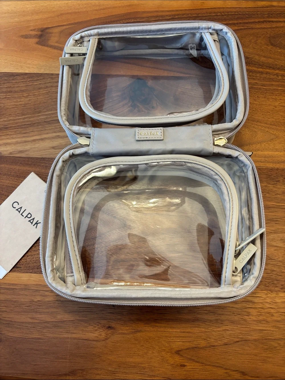 NWT New Calpak Beige Clear Travel Cosmetic Case
